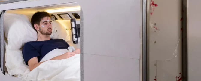 Man sitting in testing bed with monitors on