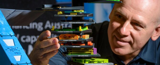 DEWC staff member demonstrating a plastic model of an electronic system