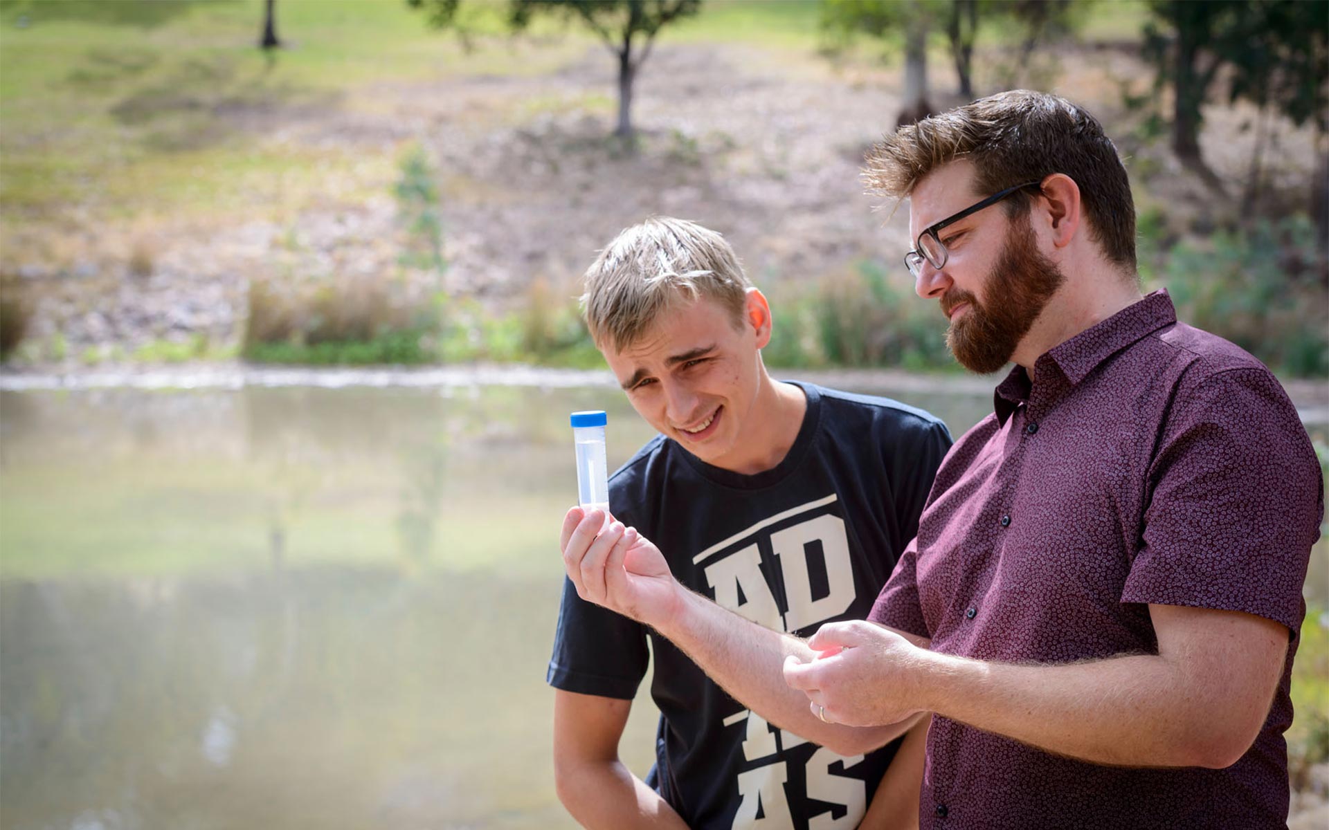 Two scientists inspecting a sample outdoors