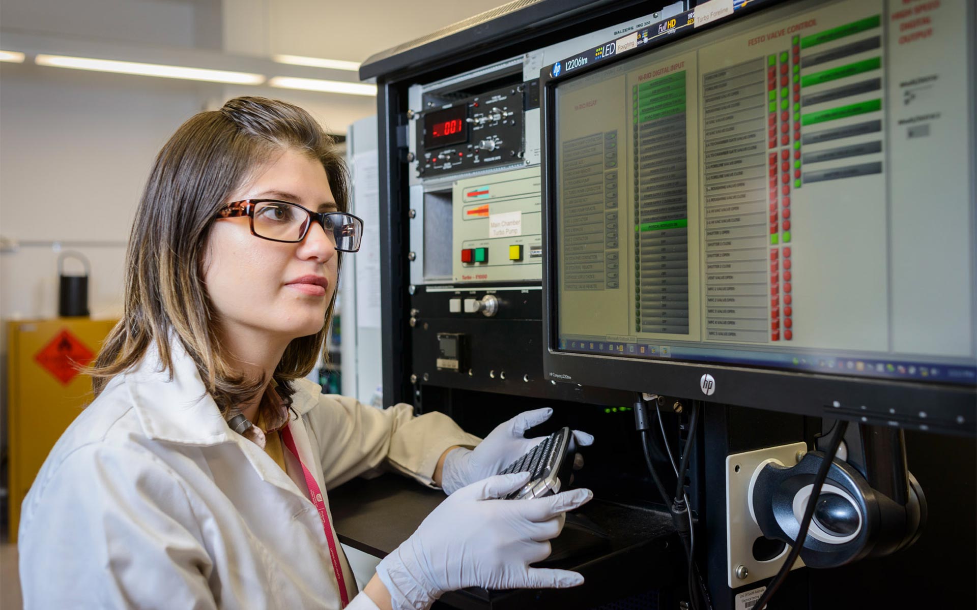 Female UniSA scientist opperating computer equipment