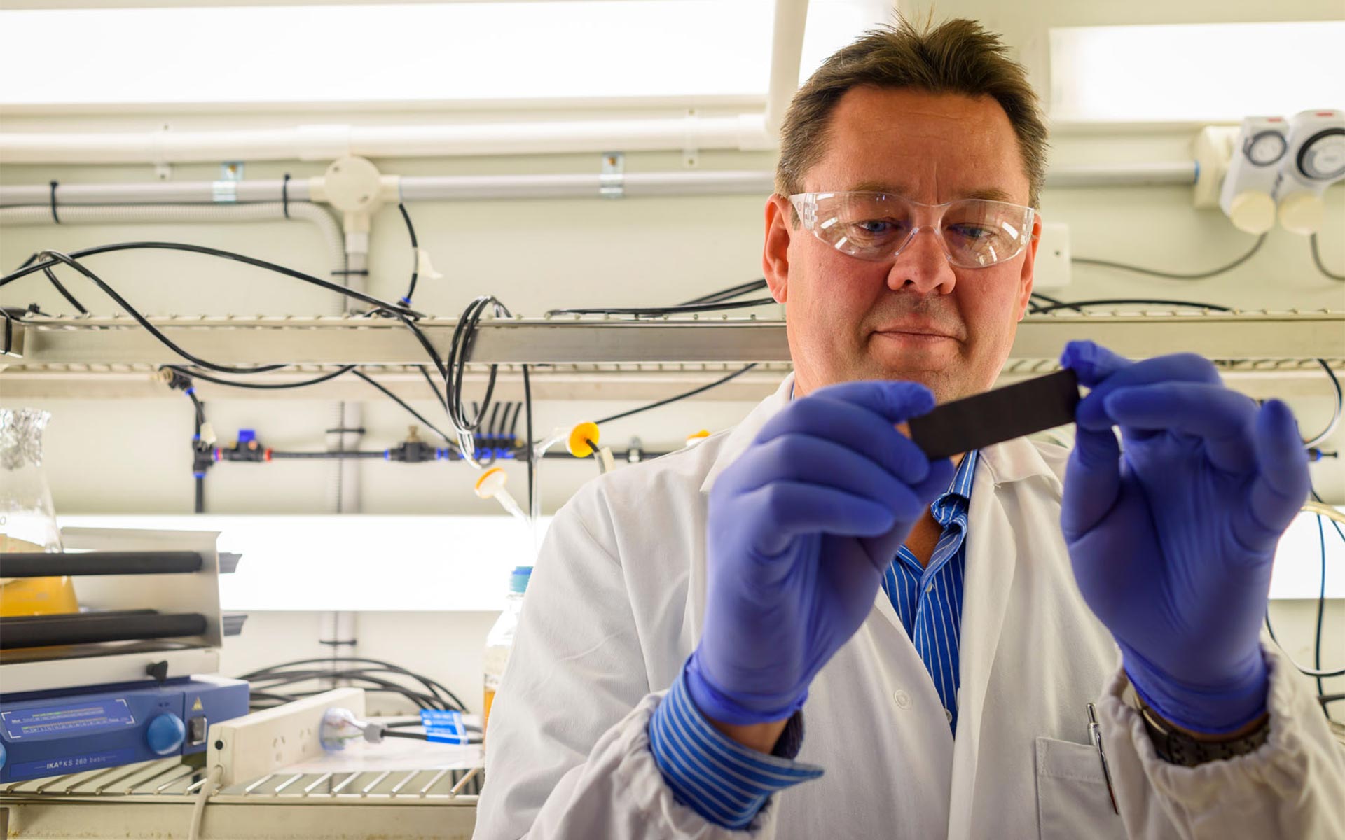 Male scientist in lab handling sample