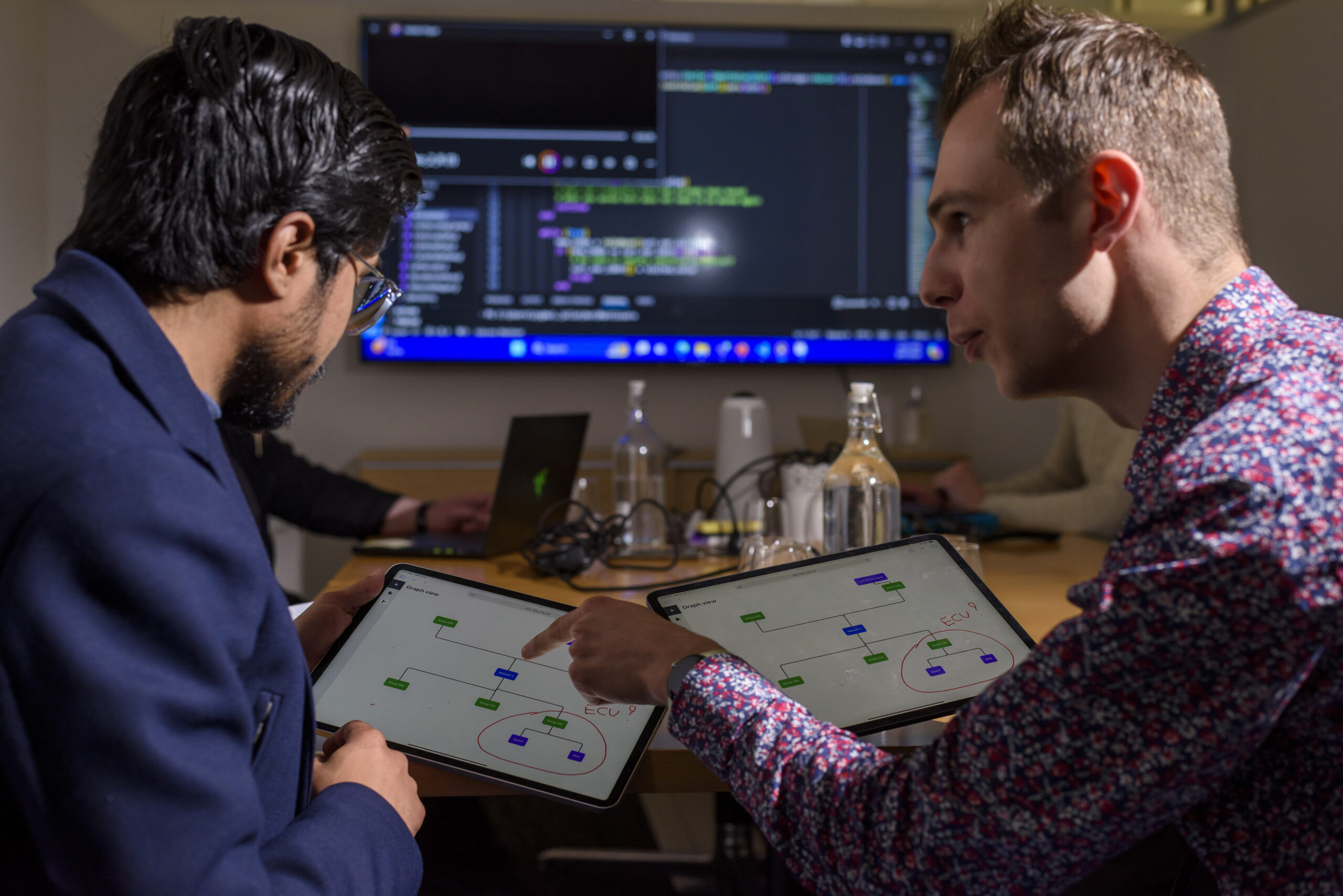 Two men looking at electronic screens