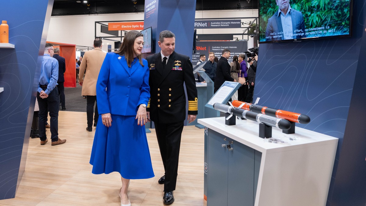Two people viewing new technology at a defence conference.